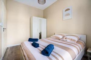 a bedroom with a large bed with blue pillows on it at Comédie ST-Roch - T2 - Hypercentre Gare - CLIM & NETFLIX in Montpellier