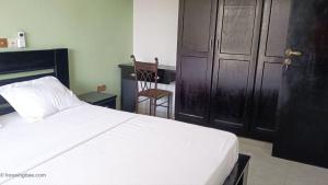 a bedroom with a white bed and a black door at Résidence Inspire in Douala +11 photos