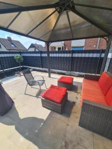 a patio with couches and a table and a chair at Villa basement Apartment in Ennigerloh