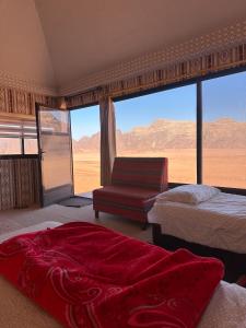 a bedroom with two beds and a couch and a window at Milky Way Bedouin Camp in Wadi Rum