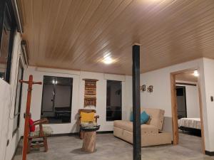 a living room with a couch and a wooden ceiling at Refugio rural MITA in Zipacón
