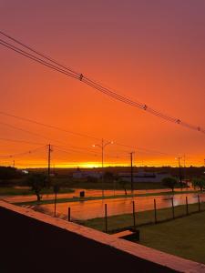 an orange sky with the sun setting in the distance at AL&V Hotel in Santa Tereza do Oeste