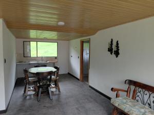 a room with a table and chairs and a kitchen at Refugio rural MITA in Zipacón