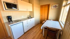 a small kitchen with a table and a microwave at Fossatún Sunset Cottage in Fossatún