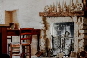 a living room with a stone fireplace with two chairs at B&B Lo Gnomo in Pennapiedimonte