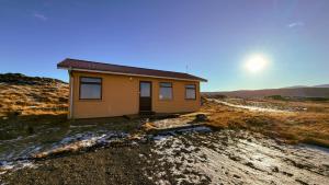 a small house sitting on top of a hill at Fossatún Sunset Cottage in Fossatún