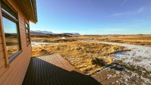 a house with a balcony looking out at a field at Fossatún Sunset Cottage in Fossatún +21 photos