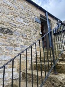 a stone building with stairs leading to a door at The Brosterfield Suite - Brosterfield Farm in Bakewell