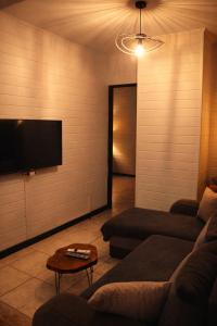 a living room with a couch and a flat screen tv at Là-Haut in Le Tampon