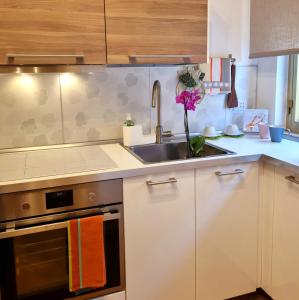 a kitchen with white cabinets and a sink and a sink at L' Approdo12 in Bari