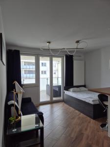 a bedroom with a bed and a desk and a couch at Apartament Golden Flight in Warsaw