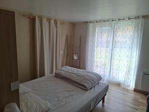 a bedroom with a bed and a large window at Gîte de Fond Carle in Miribel-Lanchâtre