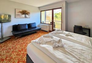 a bedroom with a large bed and a couch at Hotel Schachener Hof in Lindau