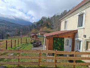 a barn with a fence next to a house at Gîte de Fond Carle in Miribel-Lanchâtre