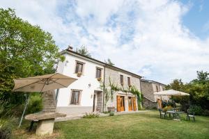 a white house with an umbrella in the yard at Acquasalsa in Agnone