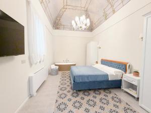 a bedroom with a blue bed and a tv at Palazzo Veneziani - Luxury Living in Monopoli in Monopoli