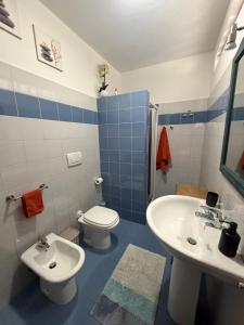 a blue and white bathroom with a toilet and a sink at Bassa Prua in Palau