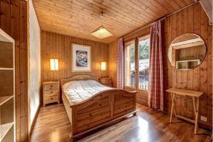 a bedroom with a bed in a wooden room at Chalet Les Frenes in Chamonix