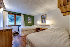 a bedroom with two beds and a window at Chalet Les Frenes in Chamonix