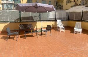 a patio with chairs and an umbrella on a roof at vivaldi casa vacanza in Caserta