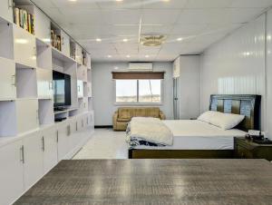 a bedroom with a bed and a couch and a television at Dhan Valley Guest House in Bhaun