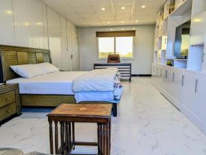 a bedroom with two beds and a table in it at Dhan Valley Guest House in Bhaun