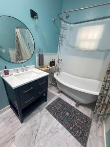 a bathroom with a tub and a sink and a mirror at Yellowstone Hideaway in Livingston +6 photos