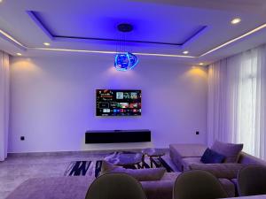 a living room with a couch and a tv at Beza Residence in Ruhengeri