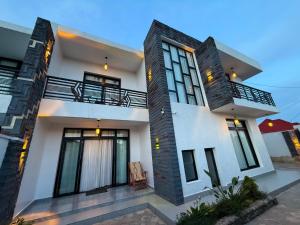 a large white house with a balcony at Beza Residence in Ruhengeri