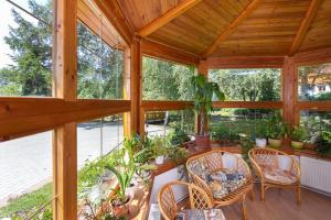 a conservatory with a table and chairs and plants at Vila Kantor in Vyšné Hágy +4 photos
