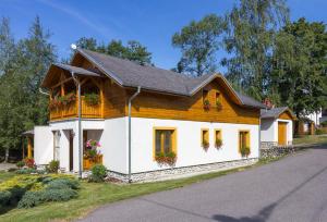 a small house with flower boxes on the windows at Vila Kantor in Vyšné Hágy