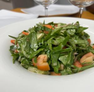 a white plate of food with greens and vegetables at Asaa View Maldives in Feridhoo