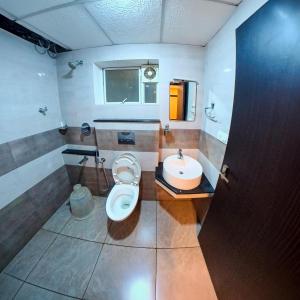 a bathroom with a toilet and a sink at krishna suites guruvayur in Guruvāyūr