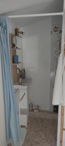 a bathroom with a blue shower curtain and a sink at Le refuge de Teddy in Solliès-Toucas