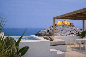 a villa with a bed and a view of the ocean at Astypalaia Hotel Palace in Astypalaia
