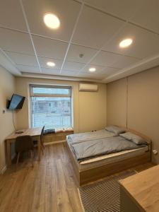 a bedroom with a bed and a desk and a window at Nõma studio in Varna City