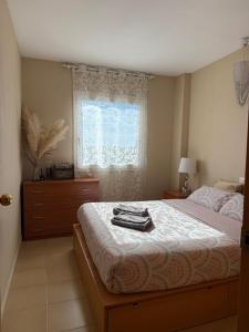 a bedroom with a bed with a dresser and a window at Apartamento MARINA PLAYA, primera linea de mar in Blanes
