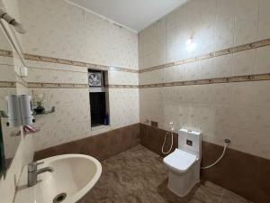 a bathroom with a toilet and a sink at Naidu Villa in Secunderabad