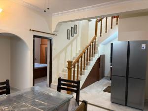 a kitchen with a refrigerator and a staircase at Naidu Villa in Secunderabad
