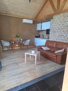 a living room with a brown leather couch and a table at Chez Théo in Trois-Ponts