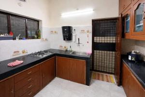 a kitchen with a sink and a stove in it at Naidu Villa in Secunderabad +26 photos
