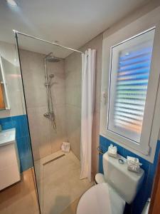 a bathroom with a toilet and a shower with a window at Delfines 61 in Corralejo +40 photos