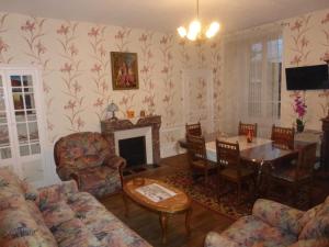 a living room with a fireplace and a table and chairs at Maison Commandant Blaison in Lapalisse