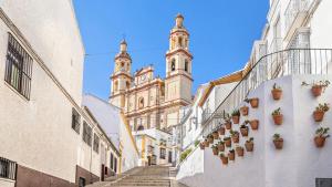 a city street with buildings and potted plants at La Casita de Isabel, Near Ronda, Sierra de Grazalema in Montecorto