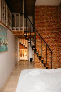 a bedroom with a brick wall and a staircase at Folwark Wielka Wieś in Główczyce