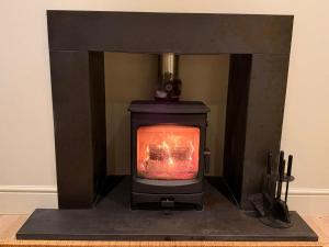 a stove with a fire in a room at Gilchrist Square in Dornoch