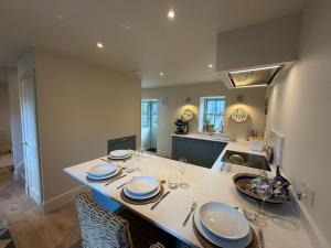 a kitchen with a table with plates and wine glasses at Gilchrist Square in Dornoch
