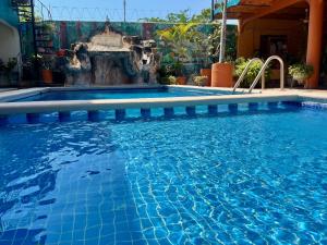 a swimming pool with a fountain in the middle at Le Colibri - 1 Min Beach - Pool - Serenity in La Peñita de Jaltemba