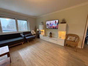 a living room with a couch and a flat screen tv at Casa Raphael direkt am Scharbeutzer Strand in Scharbeutz