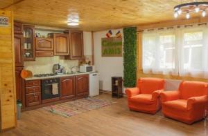 a kitchen with two orange chairs in a room at Apartament Amis tip Cabana in Poeni